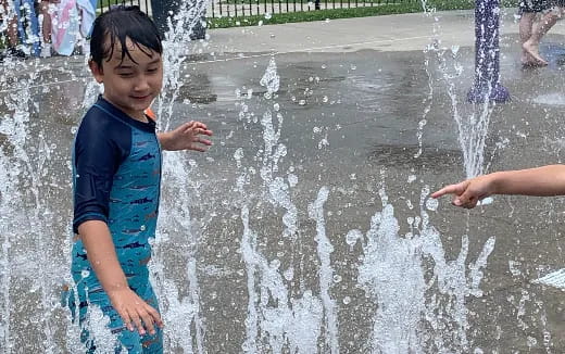 a child playing in a water fountain