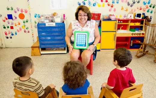 a person and several children sitting in a classroom