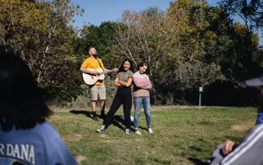 a group of people playing frisbee in a park