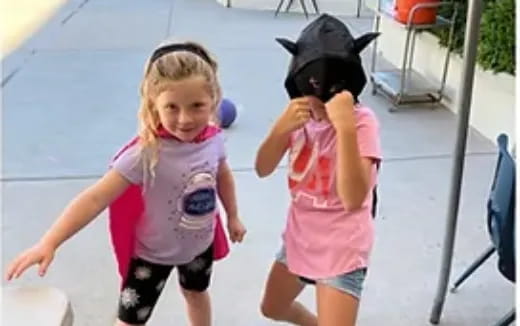 two girls wearing pink shirts and running