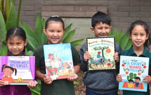 a group of children holding books