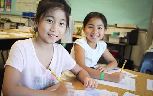 a couple of young girls sitting at a table