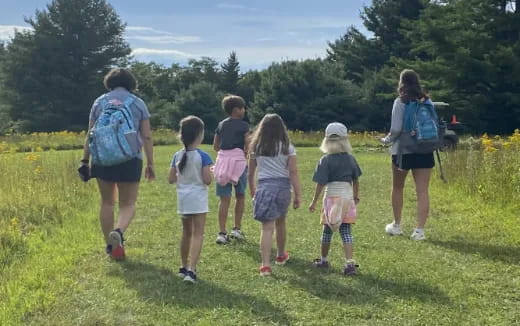 a group of people walking on a grassy field