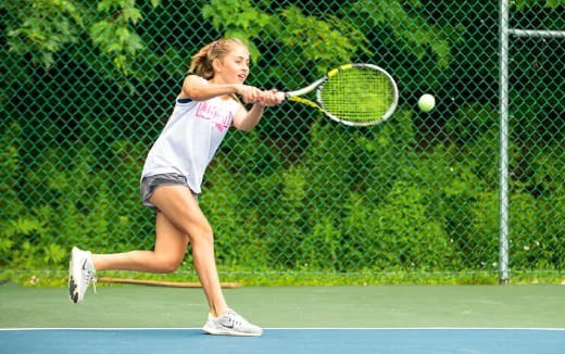 a woman hitting a ball with a tennis racket