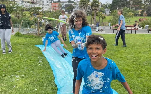 a group of children playing in a grassy area