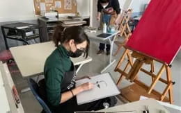 a person sitting at a desk using a laptop