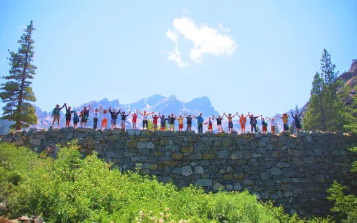 a group of people standing on a stone wall