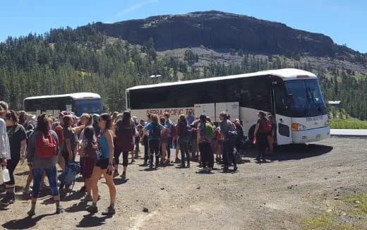 a group of people standing next to a bus