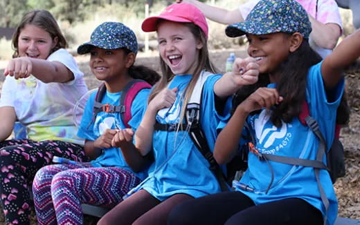 a group of young girls sitting on a bench