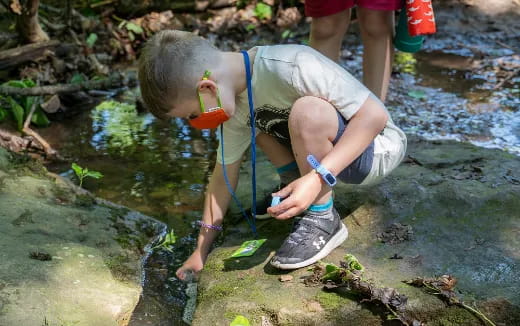 a boy squatting on a rock