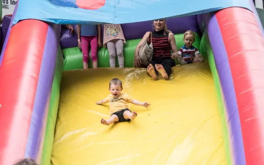 a group of children on a yellow and green slide