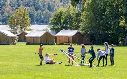 a group of people playing with bows and arrows in a field