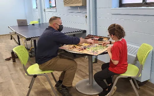 a person and a boy playing a board game