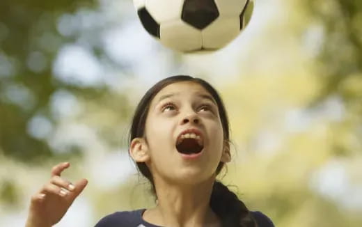 a girl with a football ball in the air