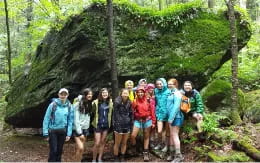 a group of people posing for a photo in front of a large tree