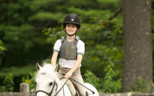 a boy riding a white horse
