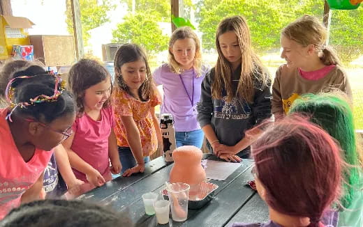 a group of children gathered around a table