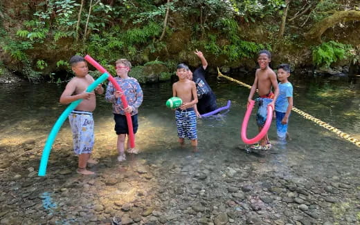 a group of kids playing in a river