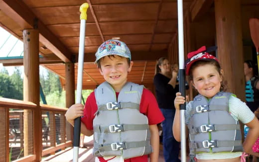 a couple of children holding onto poles