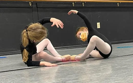 two women in black leotards