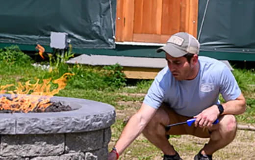 a man sitting outside with a fishing rod