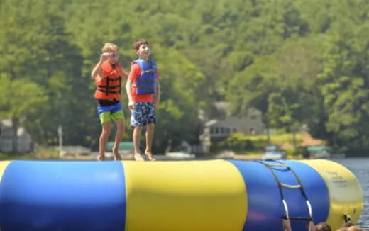 two children on a large blue and yellow tube