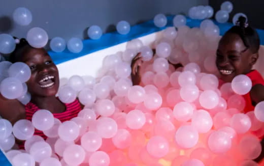 a person in a tub of pink balls