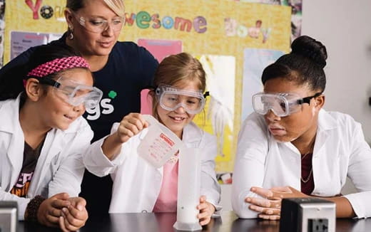 a group of people wearing white lab coats and goggles