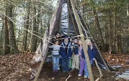 a group of people in clothing standing in a tree trunk