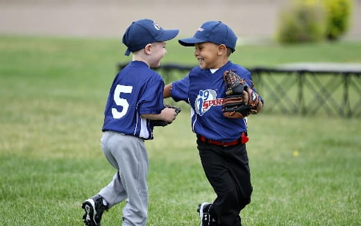 a couple of young boys playing baseball