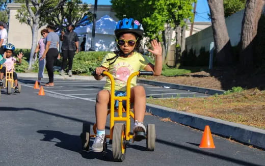 a couple of kids riding on a tricycle