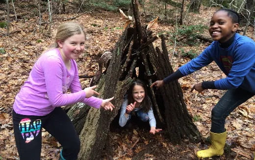 a group of people posing for a picture in front of a tree