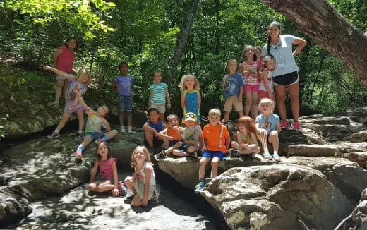 a group of children posing for a photo in front of a river