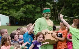 a person in a green garment surrounded by children