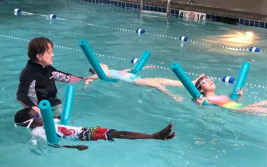 a man and a woman in a pool with a man in the water