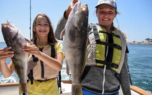 a couple of girls holding fish