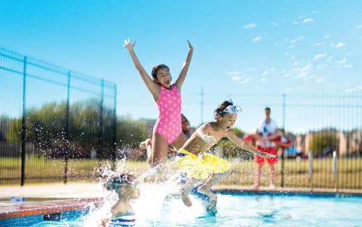 a group of girls jumping into a pool