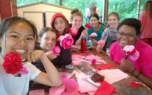 a group of children sitting at a table with flowers