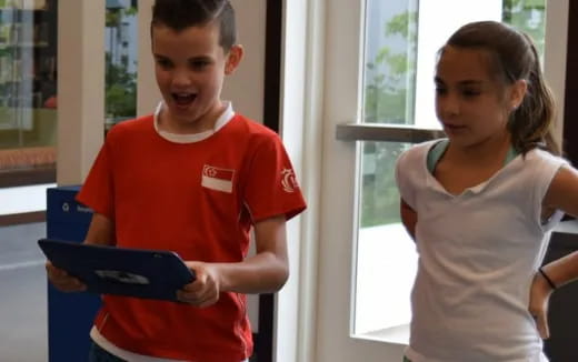 a boy and girl holding a laptop