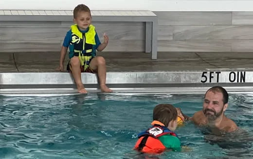 a person holding a child in a pool