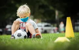 a baby playing with a football ball