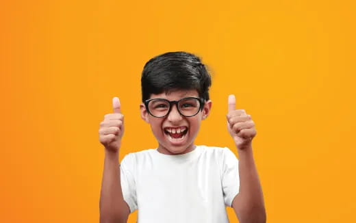 a boy with glasses and a white shirt holding up his fingers
