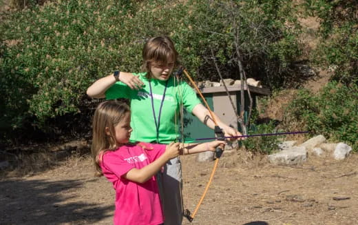 a couple of girls holding bows and arrows