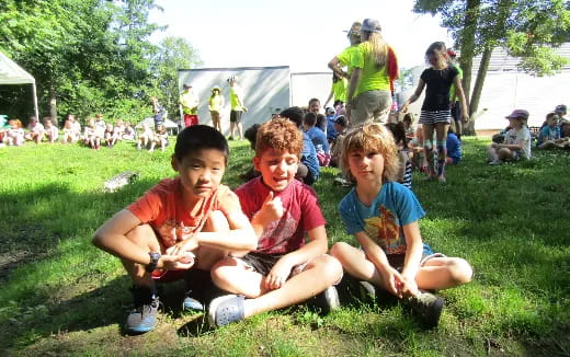 a group of kids sitting on the grass