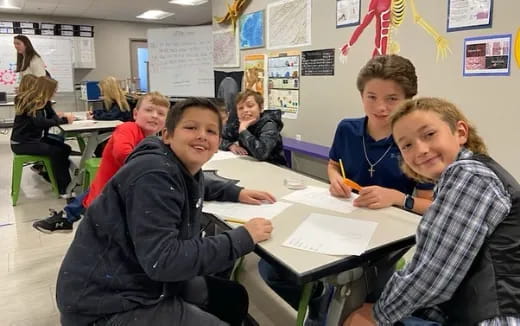 a group of children sitting at desks in a classroom