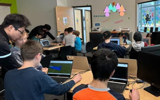 a group of people sitting at desks with computers