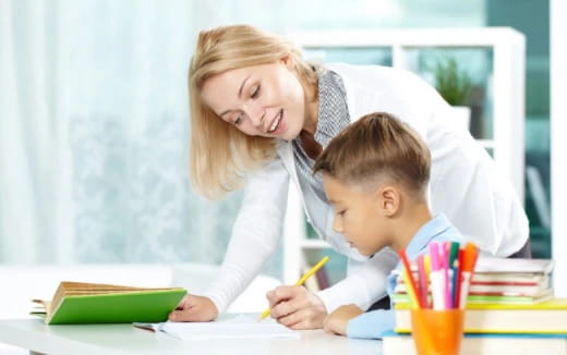 a woman and a child looking at a book