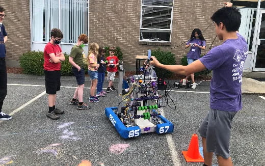 a group of people playing with a robot