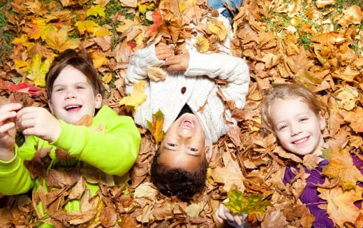 a group of children lying in the grass with flowers