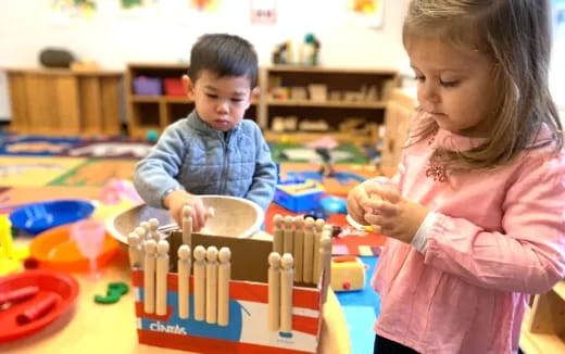 a boy and girl playing with building blocks